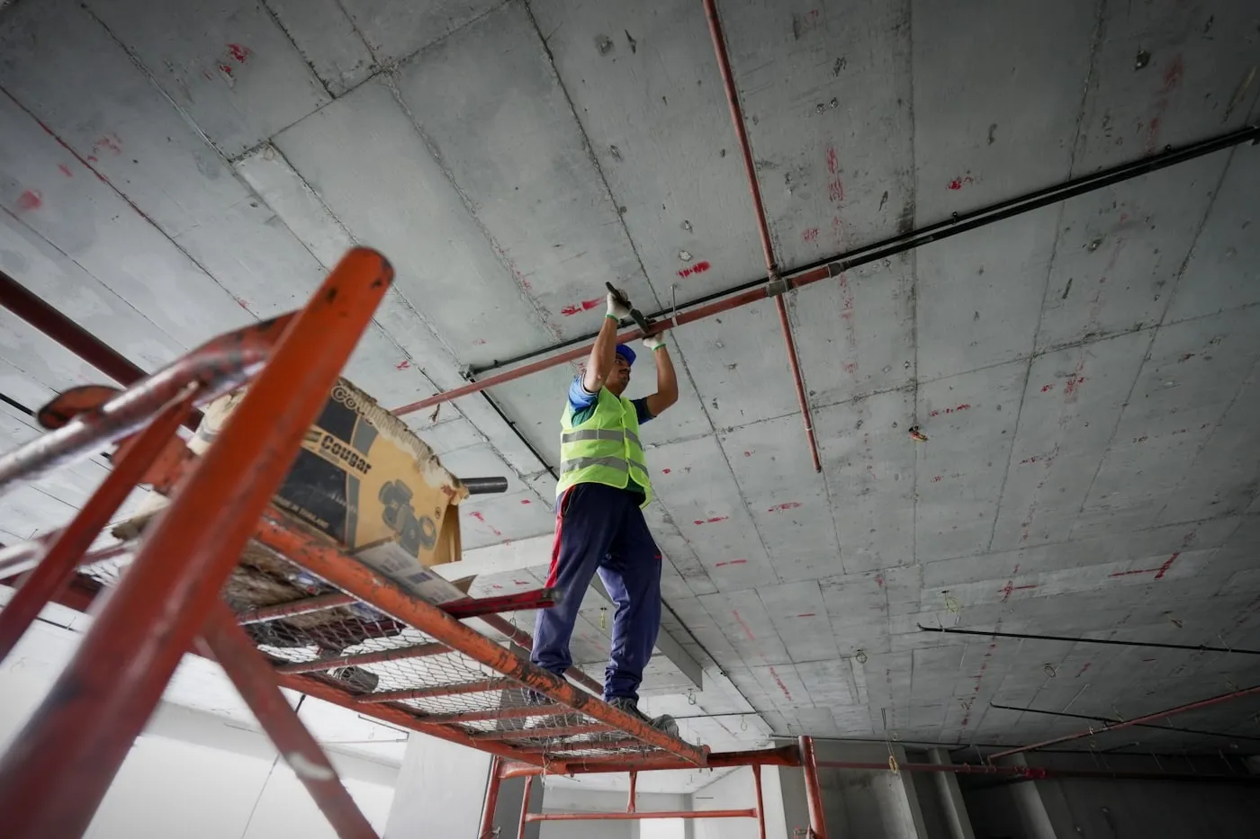 Worker on a ladder carrying out repairs to a ceiling