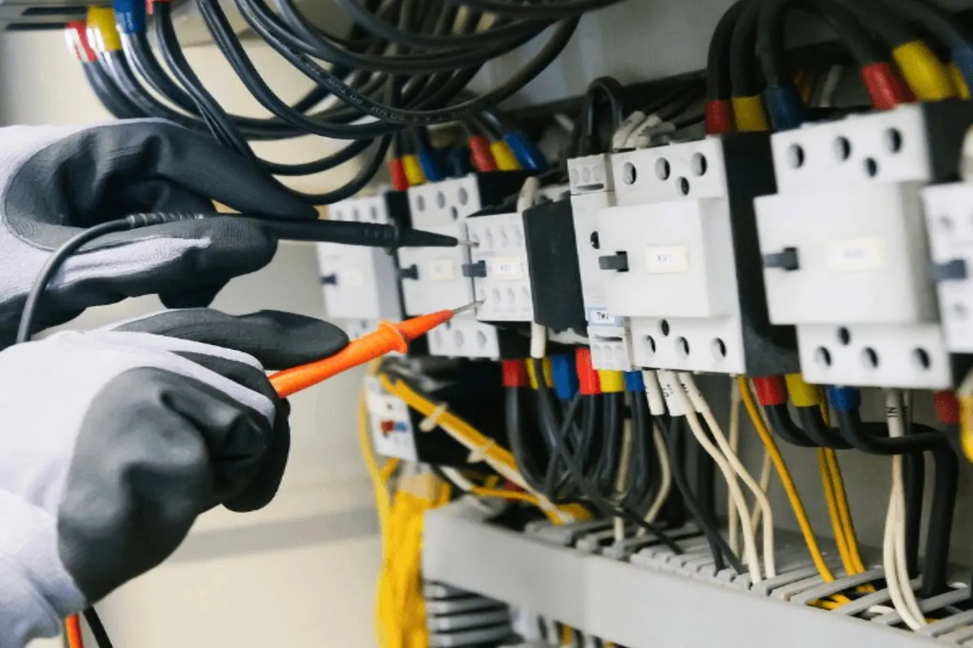 Electrician testing an electrical distribution board with a multimeter